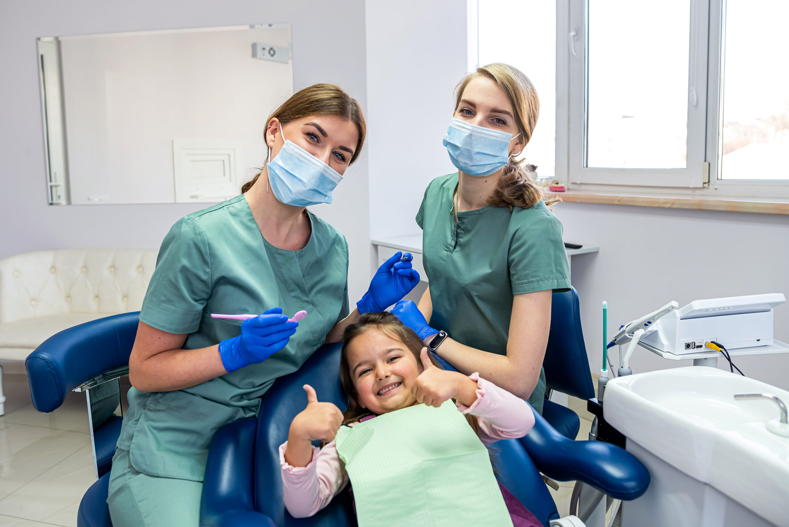 Child smiling in the dentist chair during a back-to-school dental exam